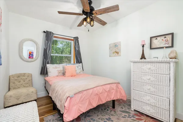 a bedroom with a bed dresser and a window