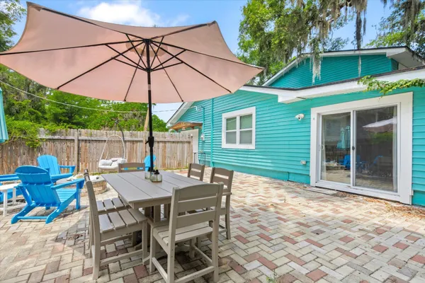 a view of a patio with couches chairs under an umbrella