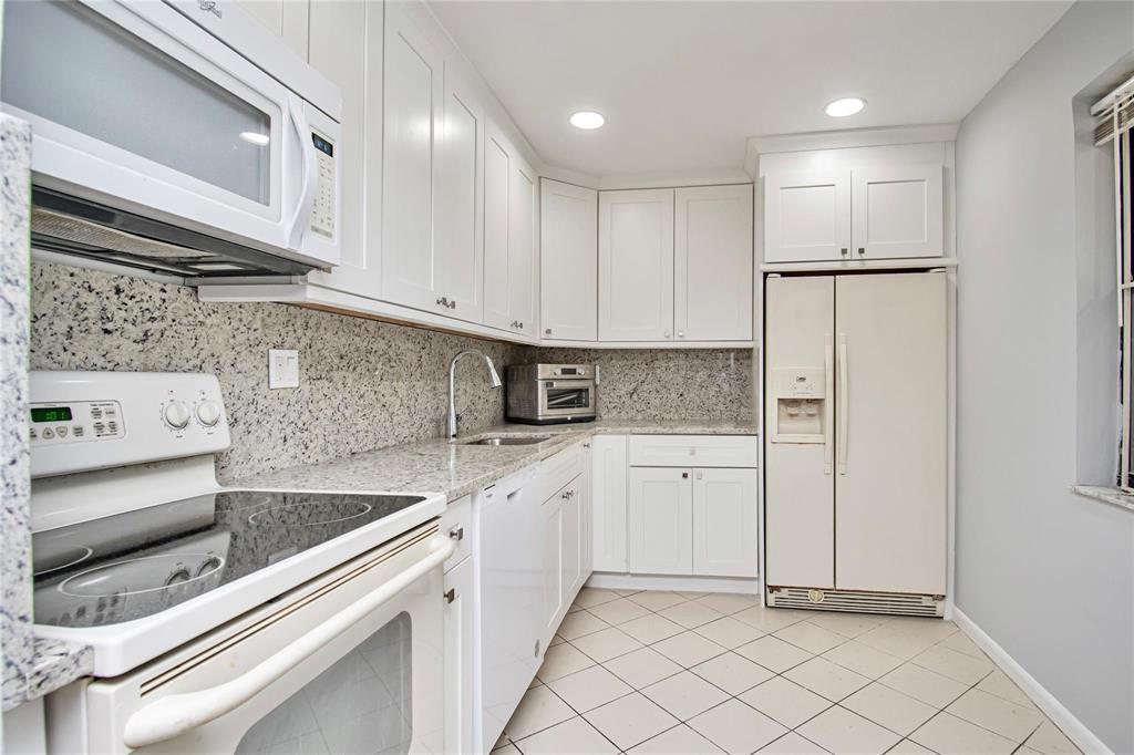8150 West McNab Road, Unit 312 Tamarac, FL 33321 - Photo 7 of 32 a kitchen with white cabinets and white appliances