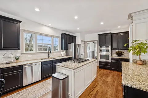 a kitchen with stainless steel appliances granite countertop a sink stove and refrigerator