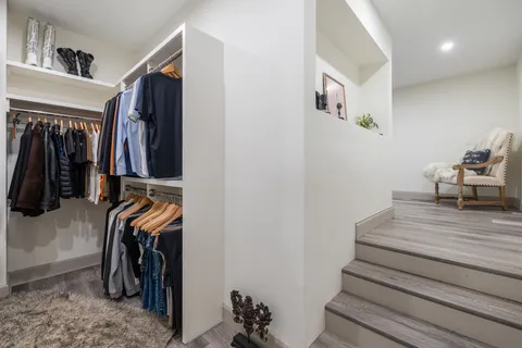 a view of walk in closet with clothes and shoes