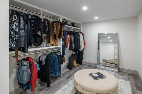 a view of walk in closet with clothes and shoes