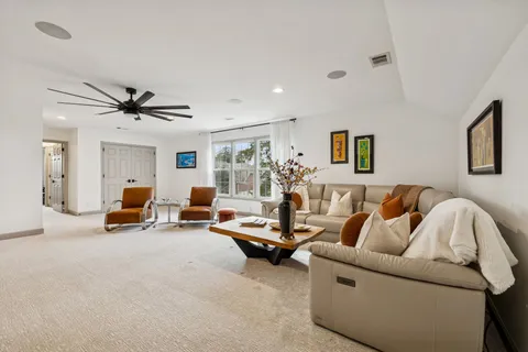 a living room with furniture and a ceiling fan