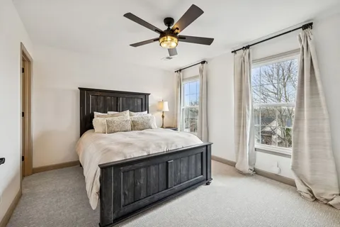 a bed sitting in a spacious bedroom next to a window