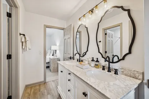 a en suite bathroom with a granite countertop sink and a mirror
