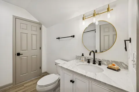 a bathroom with a sink a toilet and a mirror