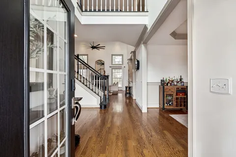 a view of hallway with wooden floor and stairs