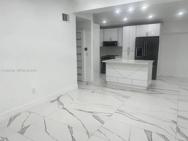 a view of kitchen with refrigerator and microwave