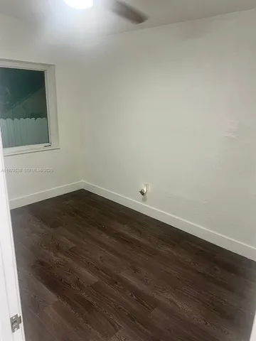 a view of a small space with wooden floor and cabinet