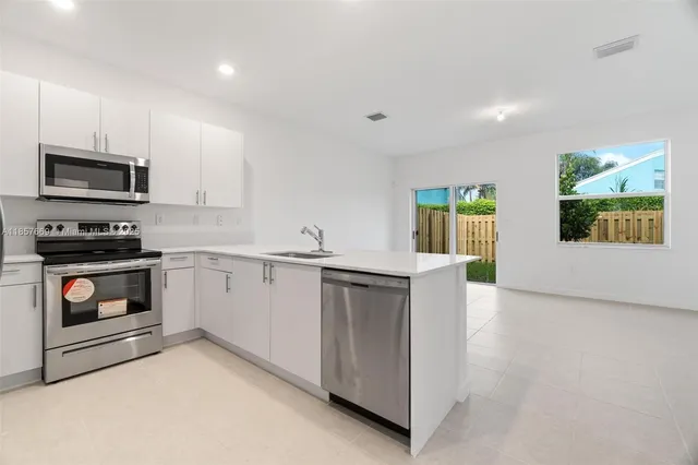 a kitchen with stainless steel appliances granite countertop a stove a refrigerator and a microwave