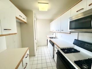 3855 Shore Parkway, Unit 3M Brooklyn, NY 11235 - Photo 6 of 11 a kitchen with a stove and a microwave