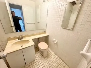 a bathroom with a sink a toilet and a mirror