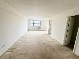 an empty room with windows and closet