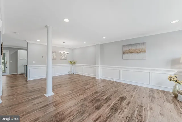 a view of empty room with wooden floor and window