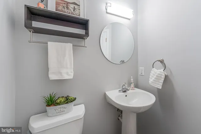 a kitchen with stainless steel appliances granite countertop a refrigerator a stove a sink and white cabinets with wooden floor