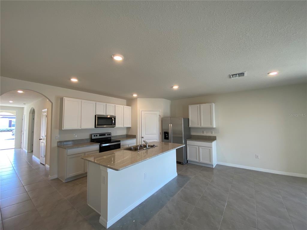 14 Hickory Course Lane Ocala, FL 34472 - Photo 3 of 20 a kitchen with stainless steel appliances a refrigerator a stove top oven and sink
