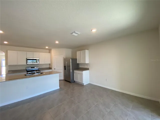a kitchen with stainless steel appliances a refrigerator and a stove top oven