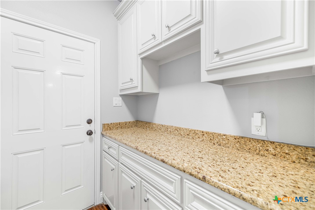 204 James Street Inez, TX 77968 - Photo 24 of 35 a kitchen with granite countertop white cabinets and a wooden floor