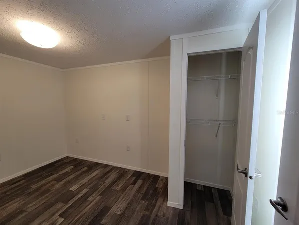 a view of a room with wooden floor and closet