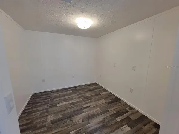 a view of a room with wooden floor and fan