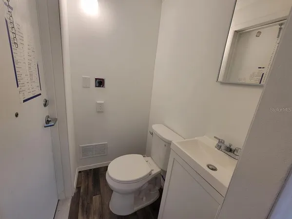 a white toilet sitting next to a white sink and vanity