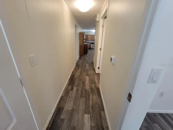 a view of a hallway with wooden floor and entryway