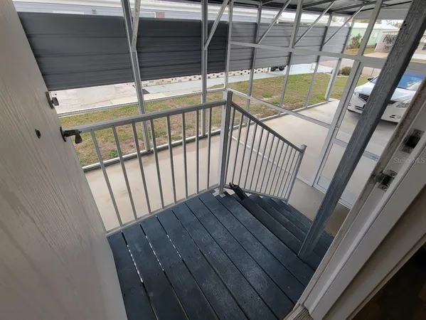 a view of staircase with railing and white walls with wooden floor
