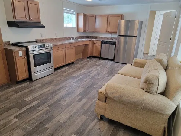 a kitchen with granite countertop a sink cabinets stainless steel appliances and a counter top space