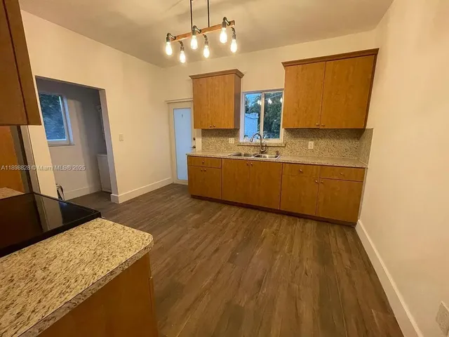 a view of kitchen with sink and refrigerator