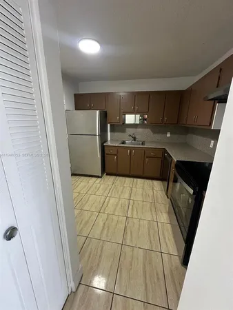 a kitchen with stainless steel appliances a refrigerator a sink a stove a microwave and cabinets