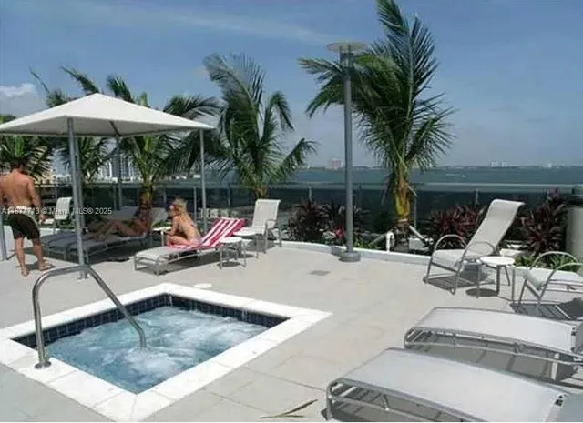 a view of a backyard with swimming pool and furniture