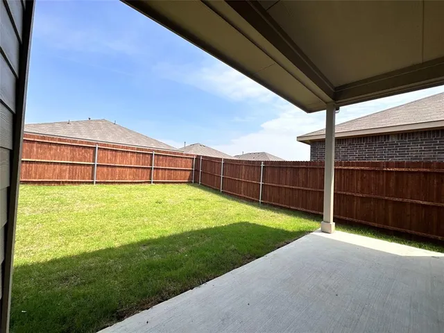 a view of a backyard with table and chairs