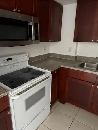 a kitchen with granite countertop white cabinets and stainless steel appliances
