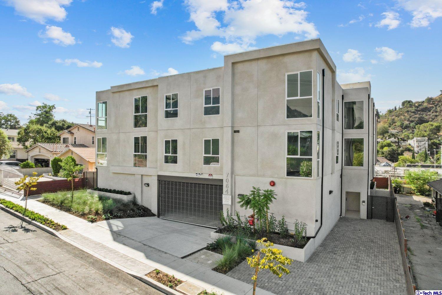 7064 Greeley Street, Unit 102 Tujunga, CA 91042 - Photo 1 of 27 a front view of a house with a garden