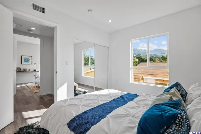 a bedroom with a bed and wooden floor