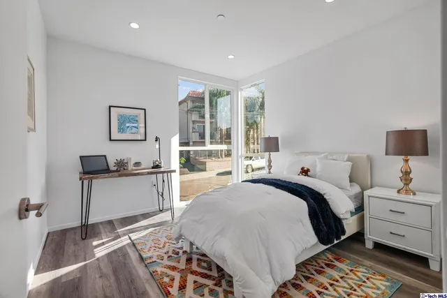 a bedroom with bed and wooden floor