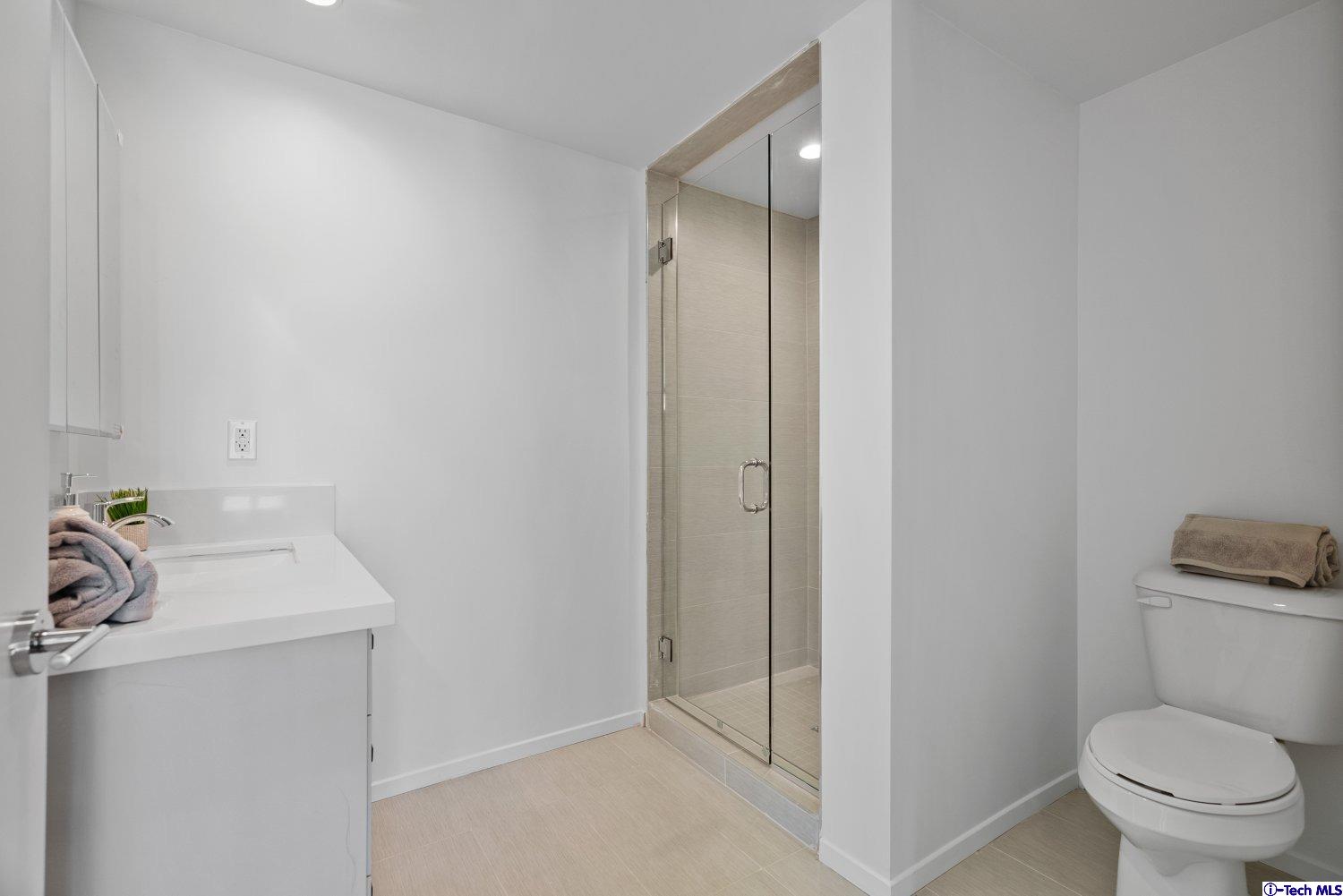 7064 Greeley Street, Unit 102 Tujunga, CA 91042 - Photo 23 of 27 a bathroom with a sink a toilet and shower