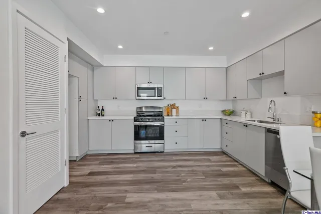 a kitchen with cabinets stainless steel appliances and a counter space