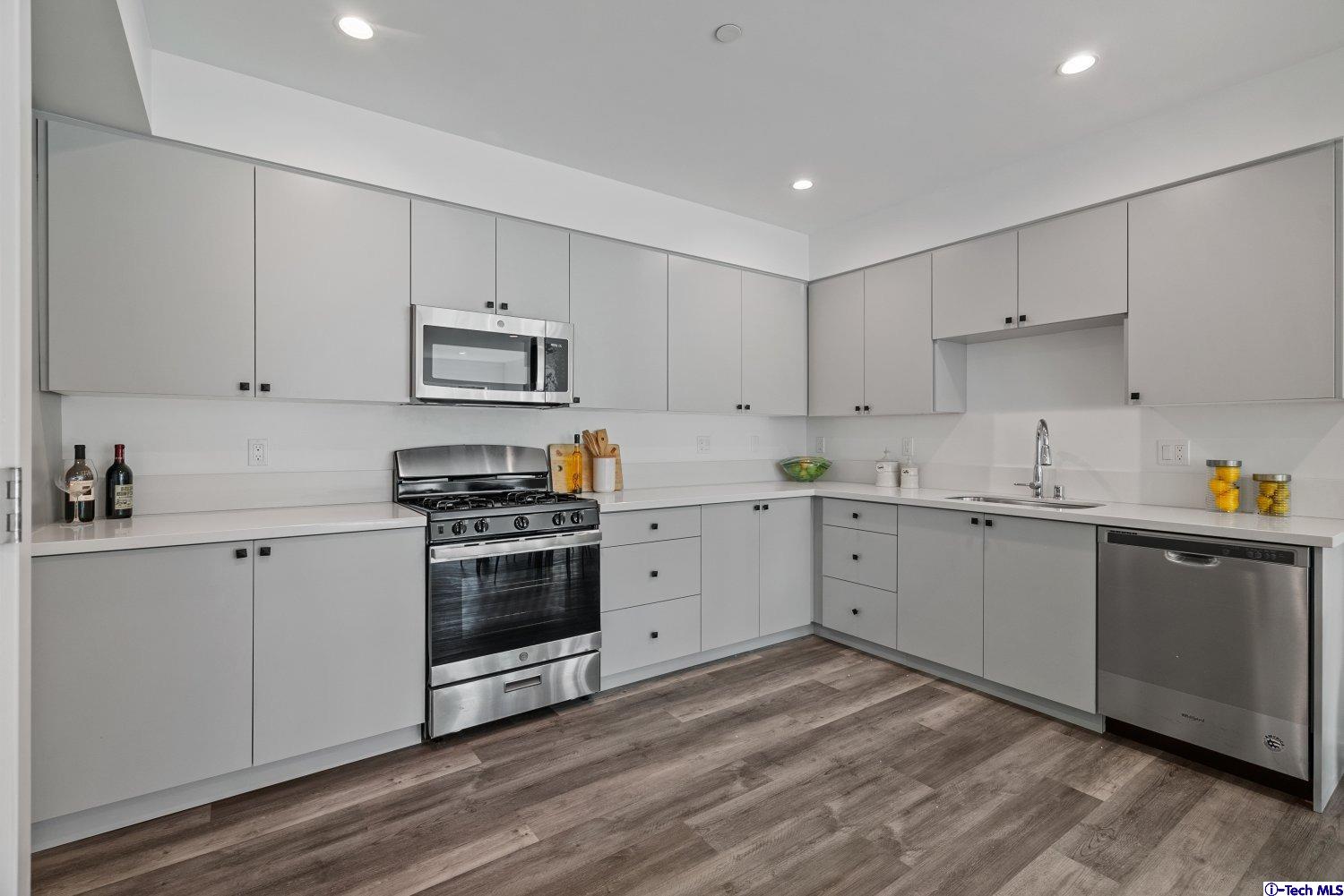 7064 Greeley Street, Unit 102 Tujunga, CA 91042 - Photo 8 of 27 a kitchen with cabinets stainless steel appliances and a counter space