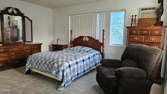 a bedroom with a bed and dresser with mirror