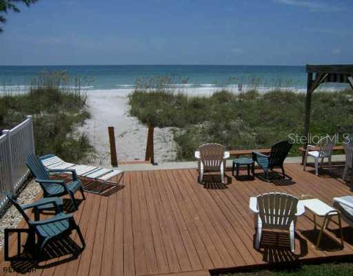 520 Beach Trail, Unit 1 Indian Rocks Beach, FL 33785 - Photo 1 of 1 a roof deck with table and chairs a barbeque with wooden floor and a yard