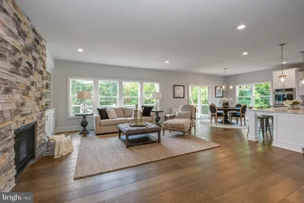 a living room with fireplace furniture and a large window