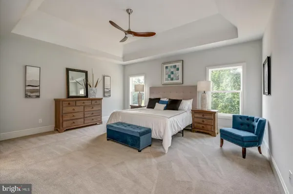 a spacious bedroom with a bed a couch and a window
