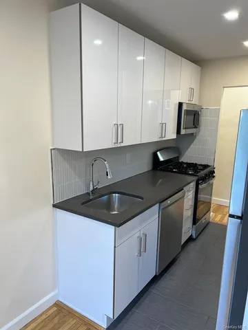 a kitchen with granite countertop a sink a stove and cabinets