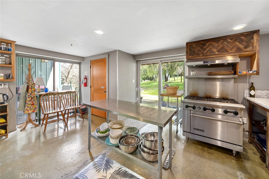 6790 West Pozo Road Santa Margarita, CA 93453 - Photo 15 of 68 a kitchen with granite countertop a stove and a dining table with wooden floor