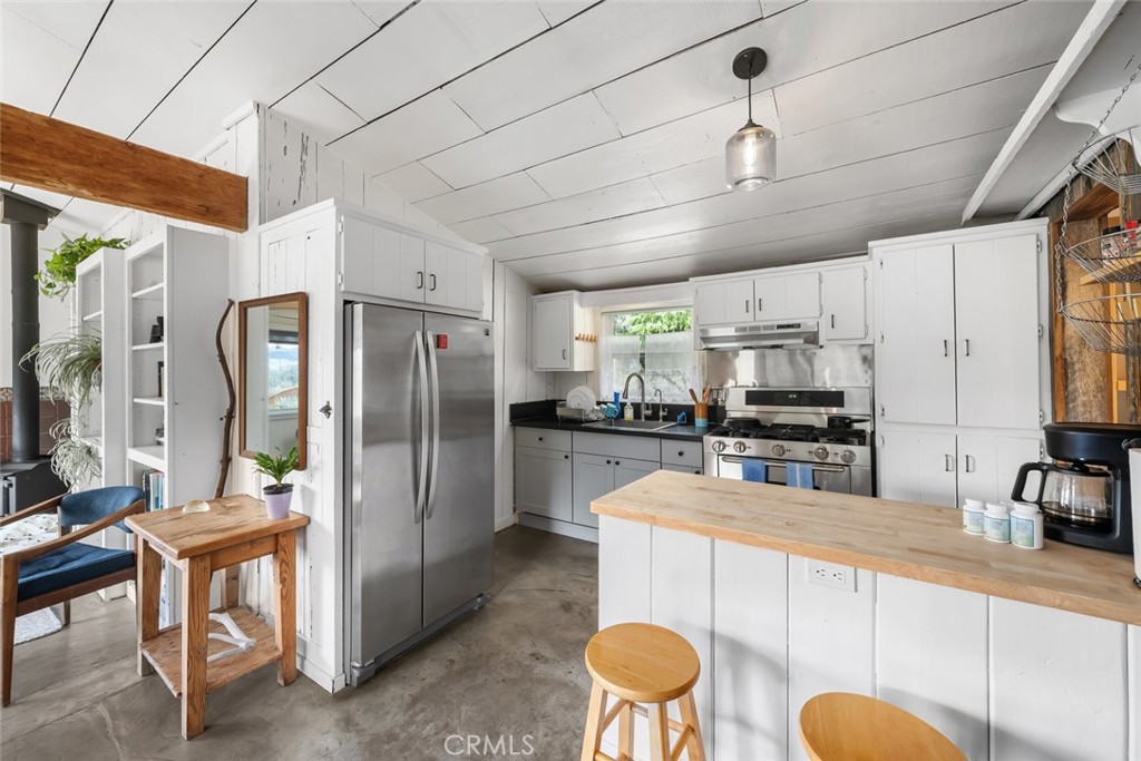 6790 West Pozo Road Santa Margarita, CA 93453 - Photo 56 of 68 a kitchen with stainless steel appliances a refrigerator a sink a stove a dining table and chairs with wooden floor