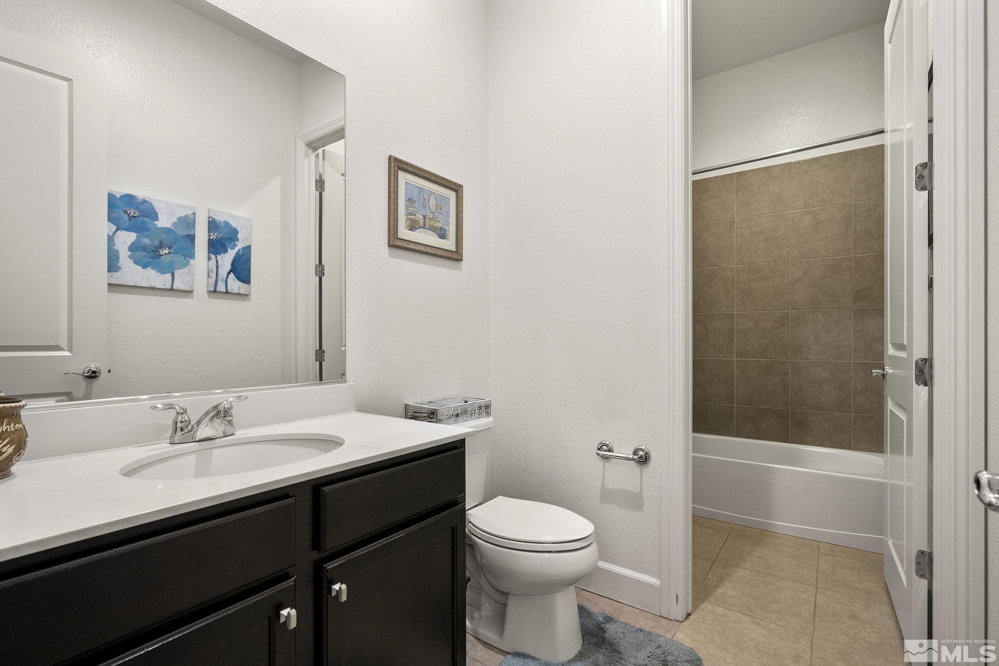 9820 Firefoot Lane Reno, NV 89521 - Photo 23 of 40 a bathroom with a sink a toilet a shower and a mirror