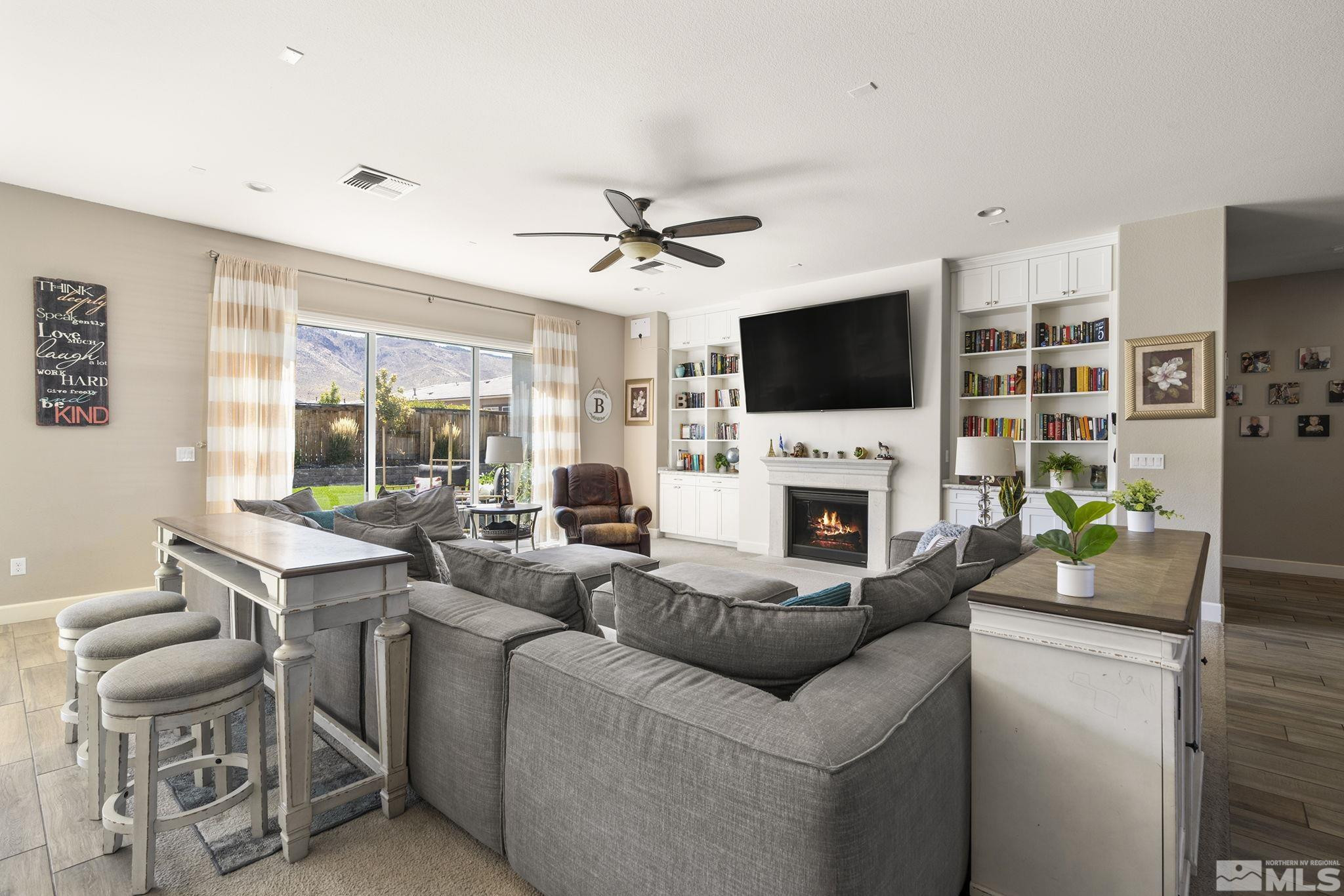 9820 Firefoot Lane Reno, NV 89521 - Photo 3 of 40 a living room with furniture a fireplace and a flat screen tv