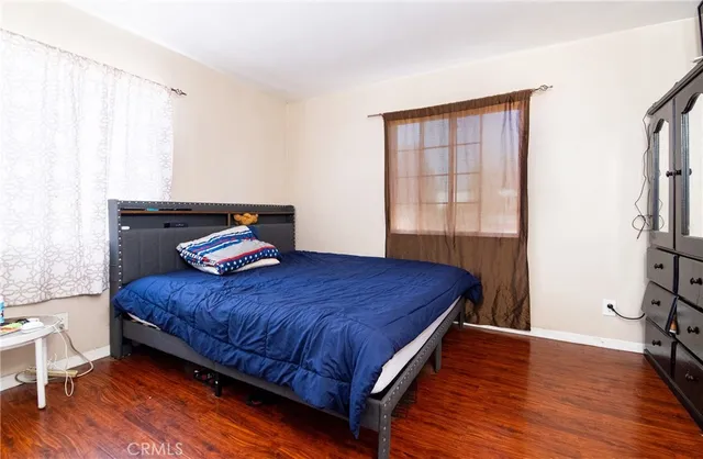 a bedroom with a bed and wooden floor