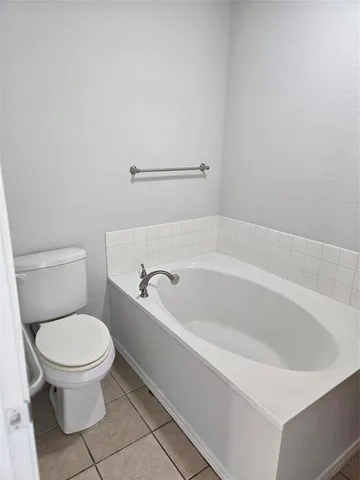 a white bath tub sitting next to a toilet